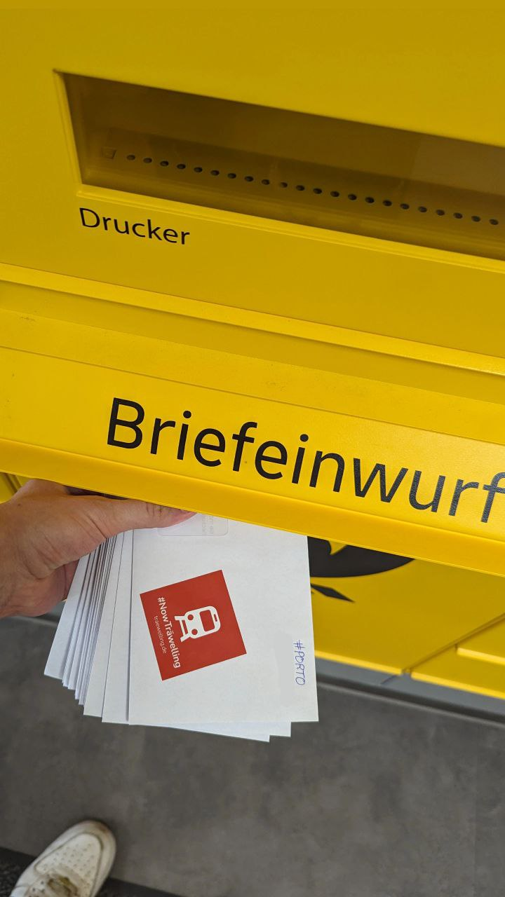 Briefe mit Träwelling Stickern werden in einen Briefkasten geworfen.